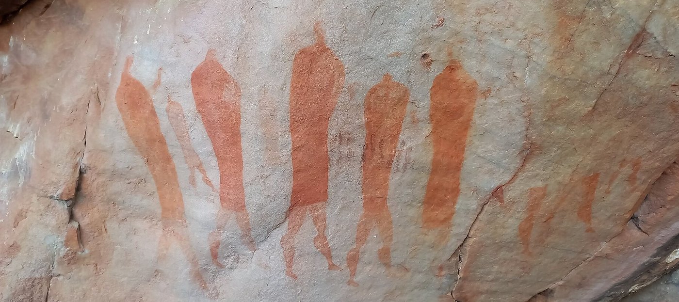 Pintura rupestre San em ocre vermelho: figuras humanas caminhando lado a lado, em Cederberg, África do Sul