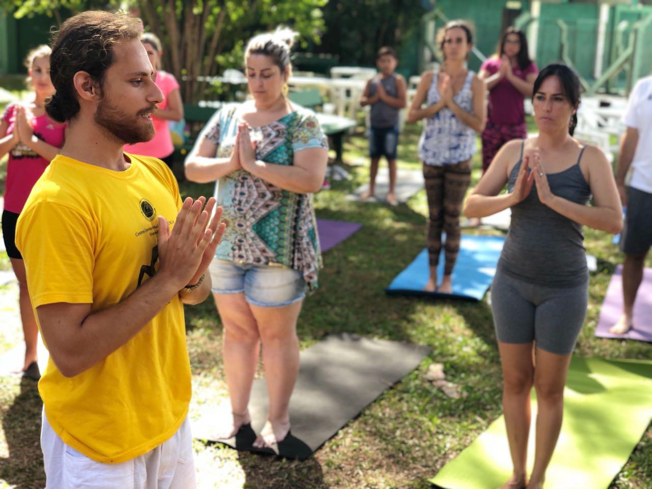 Lucas conduzindo uma prática de yoga ao ar livre